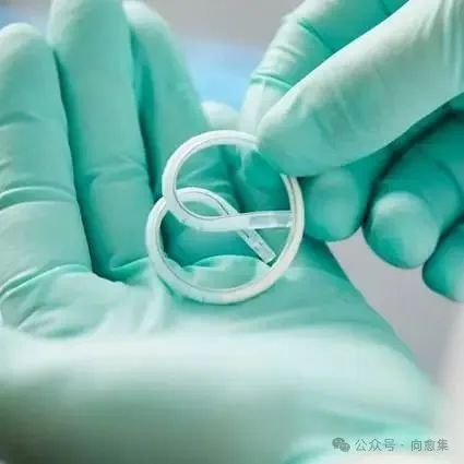 Gloved hands holding TAR-200 medical device.